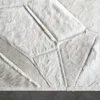 Luxury designer white geometric handmade hide rug on smooth dark grey Lexar floor.