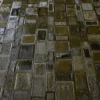 Close-up of a luxury designer rug, featuring high-end handmade patchwork hide in brown and olive tones.