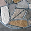 Close-up of Lexar Hide 27375 high end designer rug, handmade in luxury hide in tan, brown and gray geometric pattern on gray floor.