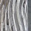 Close-up of a luxury designer Drift Hide 28893 rug with wavy light and dark fur patterns on a dark, smooth floor.