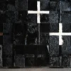 Luxury designer rug with a black patchwork surface and cross shapes in white and brown.