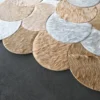 Overlapping circular patches of tan, white, and light brown fur accent this luxury designer hide rug.