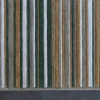 High end Jet Stream Wool 15357 designer rug with vertical green, tan, and gray stripes on a luxe dark gray floor.