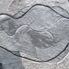 Detail of luxury custom designer rug with irregular gray and white hide pieces and dark seams.