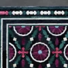 Close-up of Aubusson Hide 16290, a luxury designer rug with floral and geometric motifs on black.