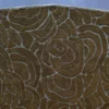 Close-up of luxury designer rug featuring raised swirl patterns on a rich brown surface.