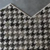 Luxury Blackdog Wool 15851 high-end designer rug in houndstooth pattern on concrete floor with a zigzag edge.