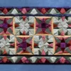 The Fancy Hide 16177 luxury designer rug showcases geometric stars in vibrant hues with a black border.