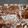 Quiver Hide 14869 luxury designer rug with brown and white handmade hide patches on a gray floor.