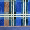 Luxury handmade hide designer rug in blue, teal, and brown patchwork on blue floor.