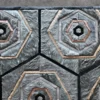 Close-up of a luxury designer rug featuring geometric hexagons in grey, beige, and black.