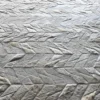Close-up of a luxury handmade hide rug in a gray and white herringbone pattern, designer high end rug texture.