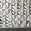 Close-up of Esperanza Hide 27929, a luxury designer handmade hide rug with gray and white geometric pattern on a dark floor.