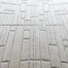 Close-up of luxury handmade wool and silk designer rug in light beige, showing a raised geometric pattern.