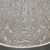 Luxury handmade wool and silk circular designer rug in beige with raised topographic-inspired pattern.