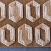 Luxury custom wool and silk designer rug in brown with beige hexagon pattern showcased on a gray floor.