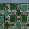 Luxury designer rug featuring green geometric shapes on gray, a high-end handmade hide rug for modern interiors.