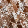 Close-up of a luxury designer rug with brown and white handmade hide tiles in a herringbone pattern.