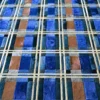 Intersecting beige lines overlay blue and brown textures, evoking a luxury designer rug style.