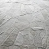 Close-up of Lexar Hide 15275 luxury designer rug with handmade fur-textured patches in light gray and beige.