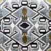 Luxury designer rug with geometric blue, black, white, and gold pattern in woven hide.