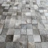 Close-up of luxury designer handmade hide rug tiles in gray and beige, arranged in a grid.