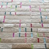 Close-up of a luxury custom handmade hide rug: beige designer tiles with colorful strips.