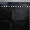 Close-up of a luxury designer black patchwork rug with white stitched border on concrete floor.