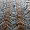 Close-up of Flow Hide 29116 luxury designer rug with wavy, rippled brown and blue texture.