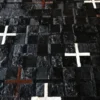 A close-up of a handmade designer rug reveals textured black hide with brown and white accents.