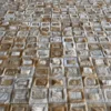Close-up of Surrender Hide 15561 luxury designer rug, handmade fur tiles with brown and white texture.