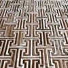 Close-up of Ripcord Hide 27036 designer rug shows interlocking white and brown patterns, embodying luxury high end handmade hide rugs.