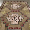 Luxury designer rug with central star motifs and geometric patterns in rich earthy tones.