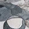 Luxury designer rug close-up, handmade from gray and black hide in an abstract pattern.