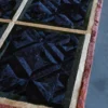 Close-up of a luxury custom designer rug with geometric pattern and plush hide panels on a gray floor.