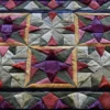 Close-up of a high end designer hide rug featuring geometric multicolored star patterns.