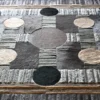 Atlas Hide 30060 luxury designer rug features geometric patterns in gray, beige, black tones with high-end handmade hide textures.