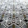 Luxury custom designer rug with a blue, white, black, and olive geometric pattern.