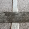 Close-up of a luxury handmade wool designer rug with beige and dark brown cross pattern.