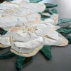 The Sweet Hide 26095 luxury designer rug with a floral motif in white, beige, and green on a sleek gray floor.