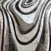 Close-up of a luxury designer rug with concentric abstract ovals in Custom Hide 25873 hues.