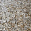 Close-up of luxury designer rug tiles in white, gray, and brown with a handmade hide texture.