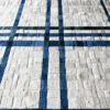Luxury designer rug with a geometric blue and green grid on white, fur-like handmade hide tiles.