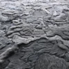 Close-up of luxury handmade hide rug with gray and black designer fur pattern texture.