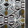 Luxury designer rug Custom Hide 27534 with geometric pattern on dark grey floor.