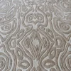 Close-up of luxury designer rug in beige, featuring embossed patterns and raised textures in handmade silk and wool.