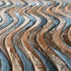 Wavy strips of brown, tan, and gray fur create a high end designer handmade hide rug.