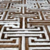 Close-up of a luxury custom rug with a geometric, maze-like brown and white pattern inspired by designer handmade hide rugs.