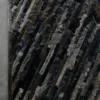 Close-up of a luxury custom designer rug, black and gray with diagonal fur-like ridges, on a smooth floor.