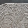 Close-up of wavy beige and gray patterns on a high end designer handmade hide rug.